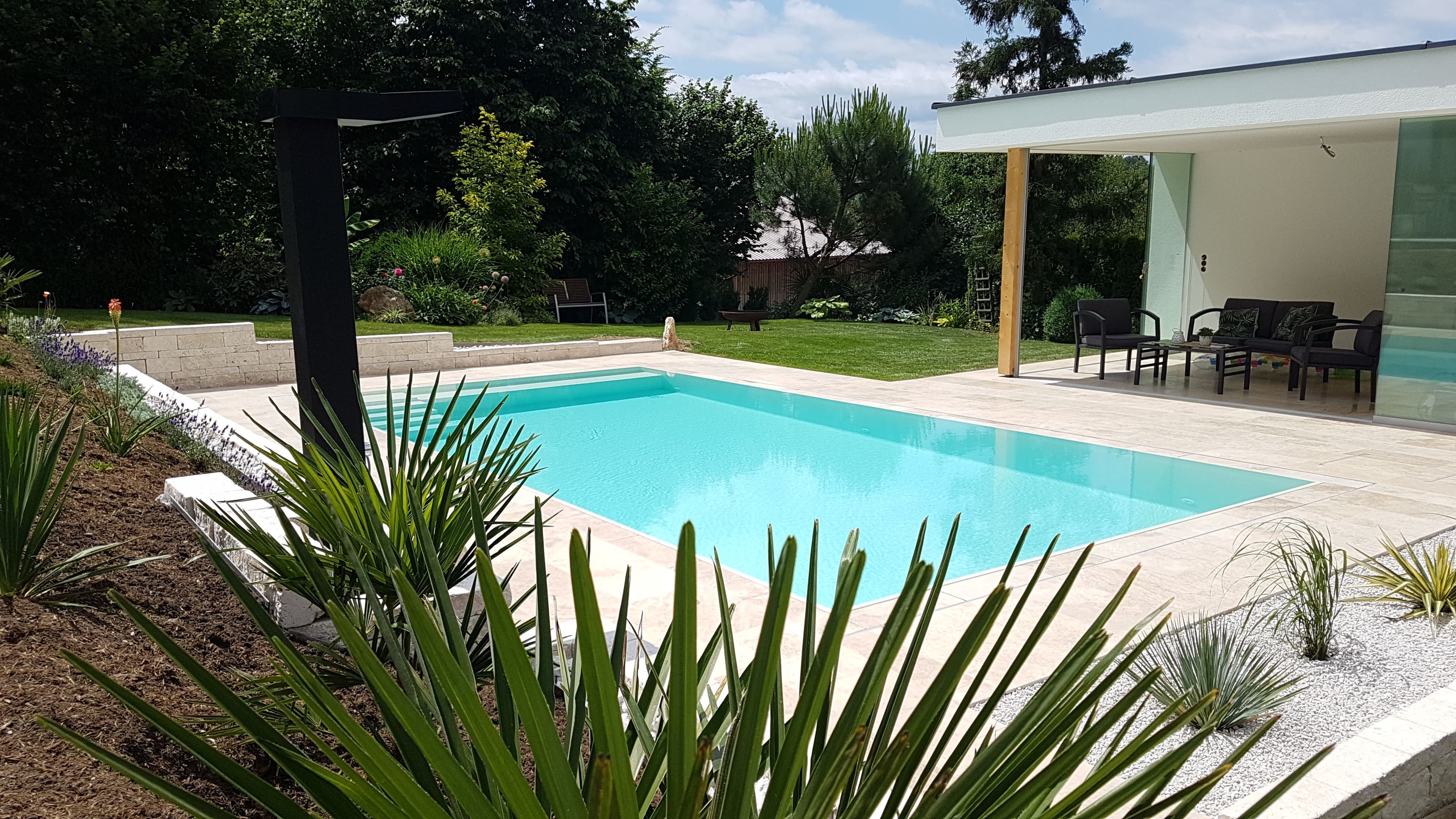Infinity-Pool auf der Terrasse eines modernen Hauses mit Blick in die Landschaft