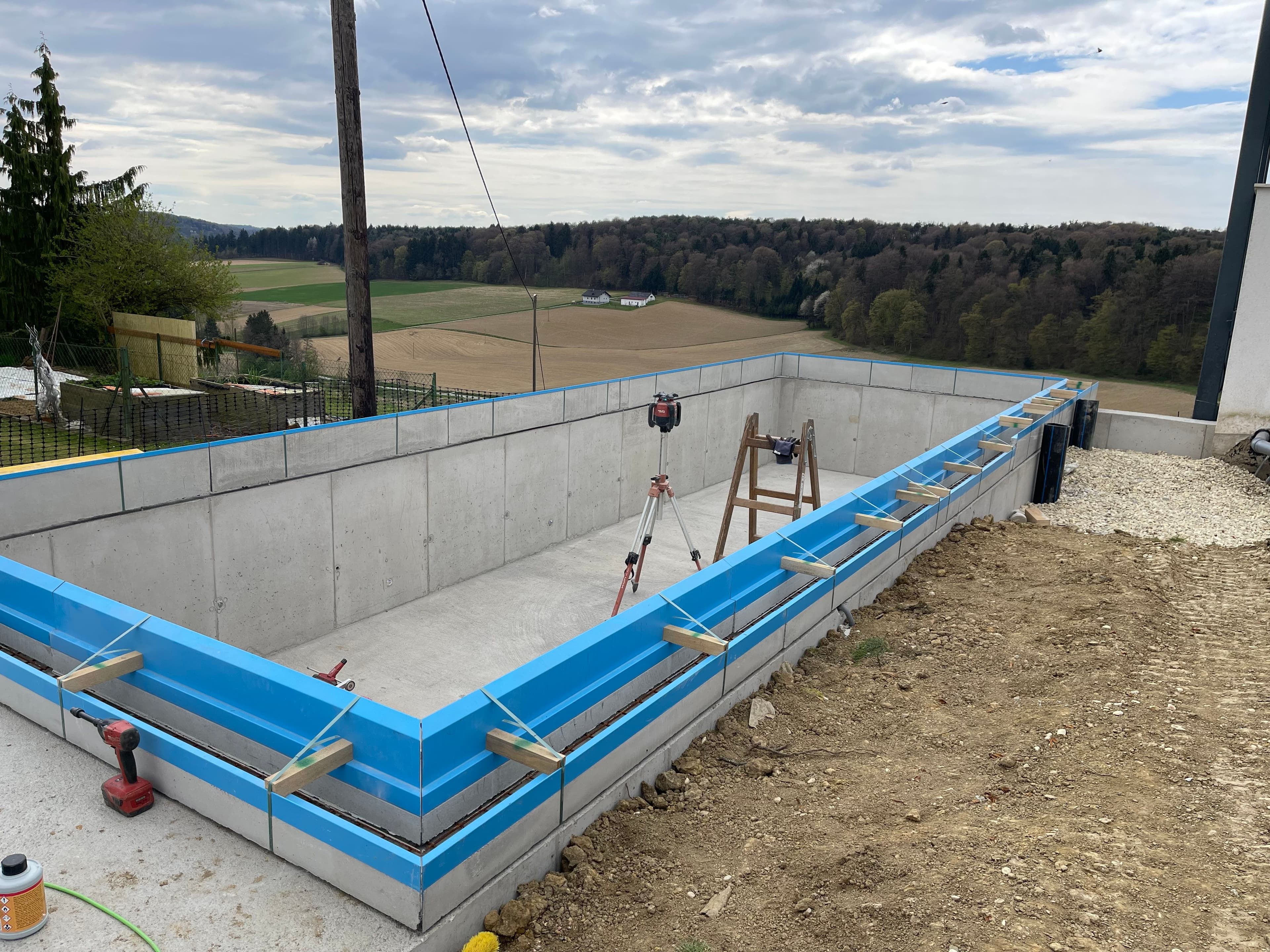 Poolbaustelle mit AquaLite-Rinnenelementen auf dem Rohbau-Becken
