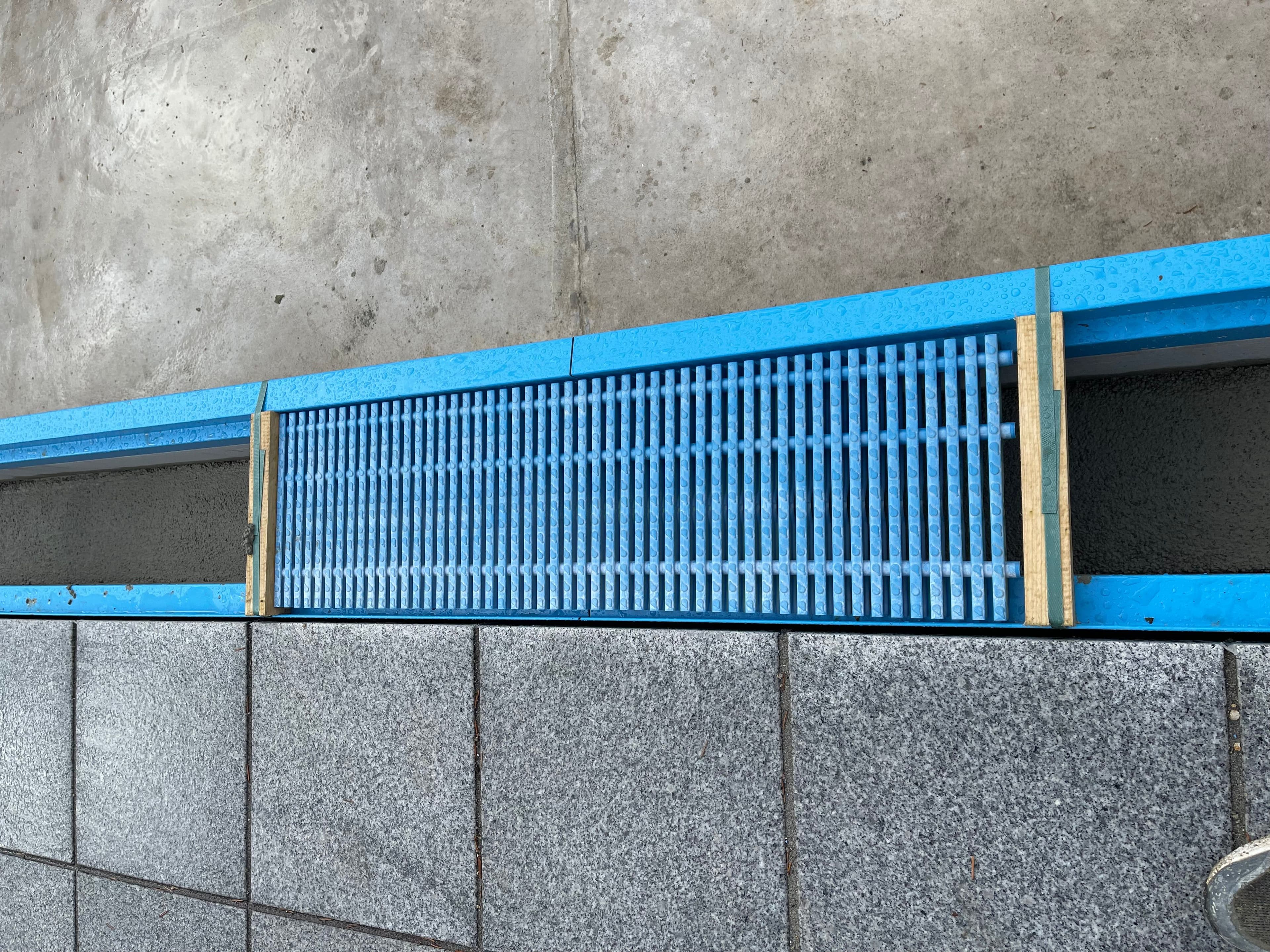 Detail einer Überlaufrinne mit Steineinlage: Der Belag der Terrasse läuft über die Rinne weiter